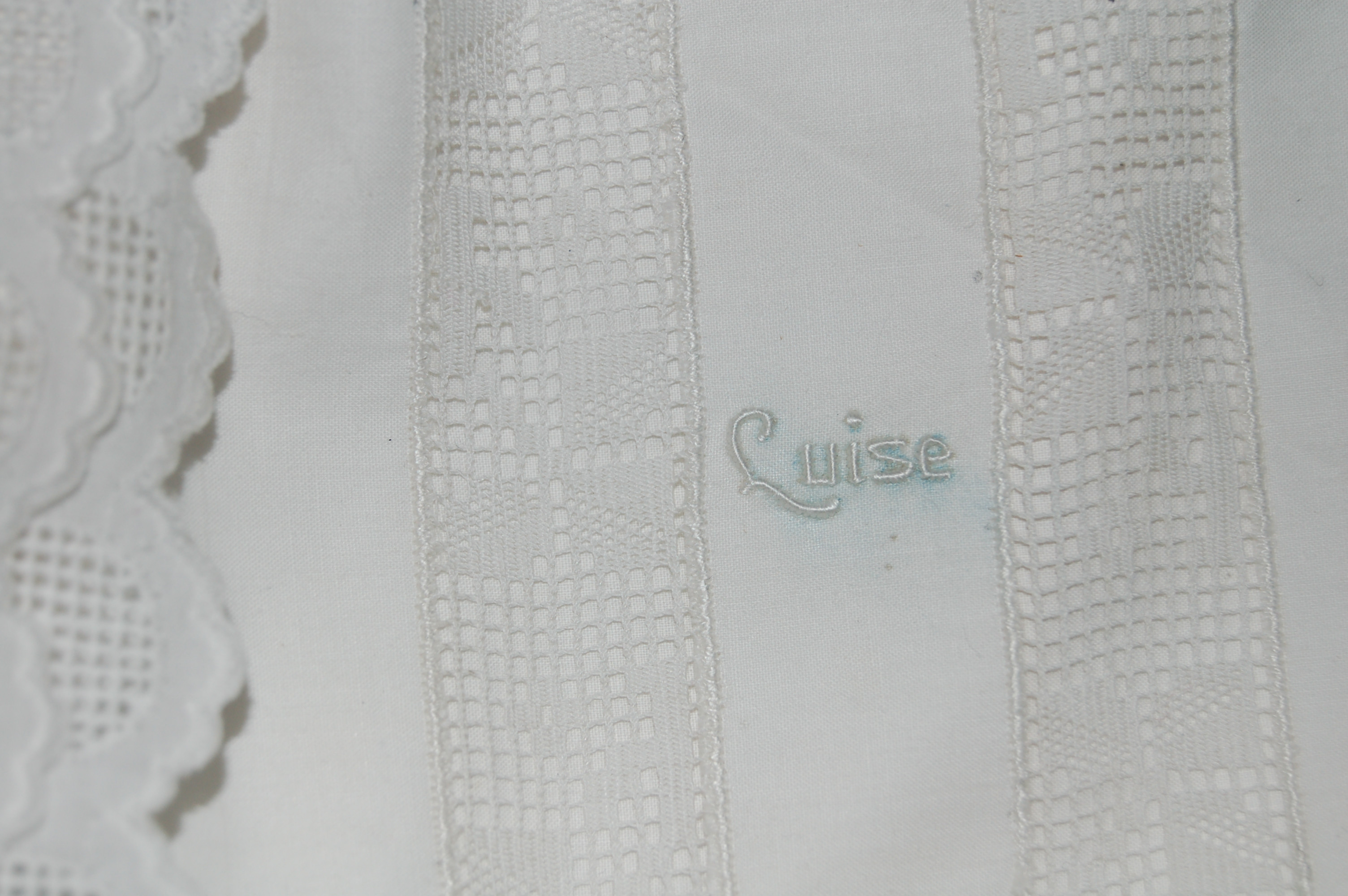 Detail weißes Unterhemd mit Spitzen und Monogramm Luise